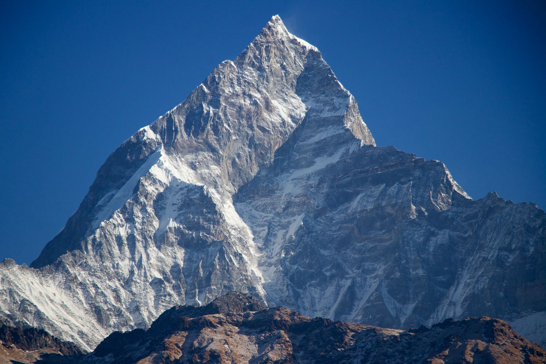 Stunning view of Machhapuchchhre mountain peak in Nepal's Himalayas under blue skies.